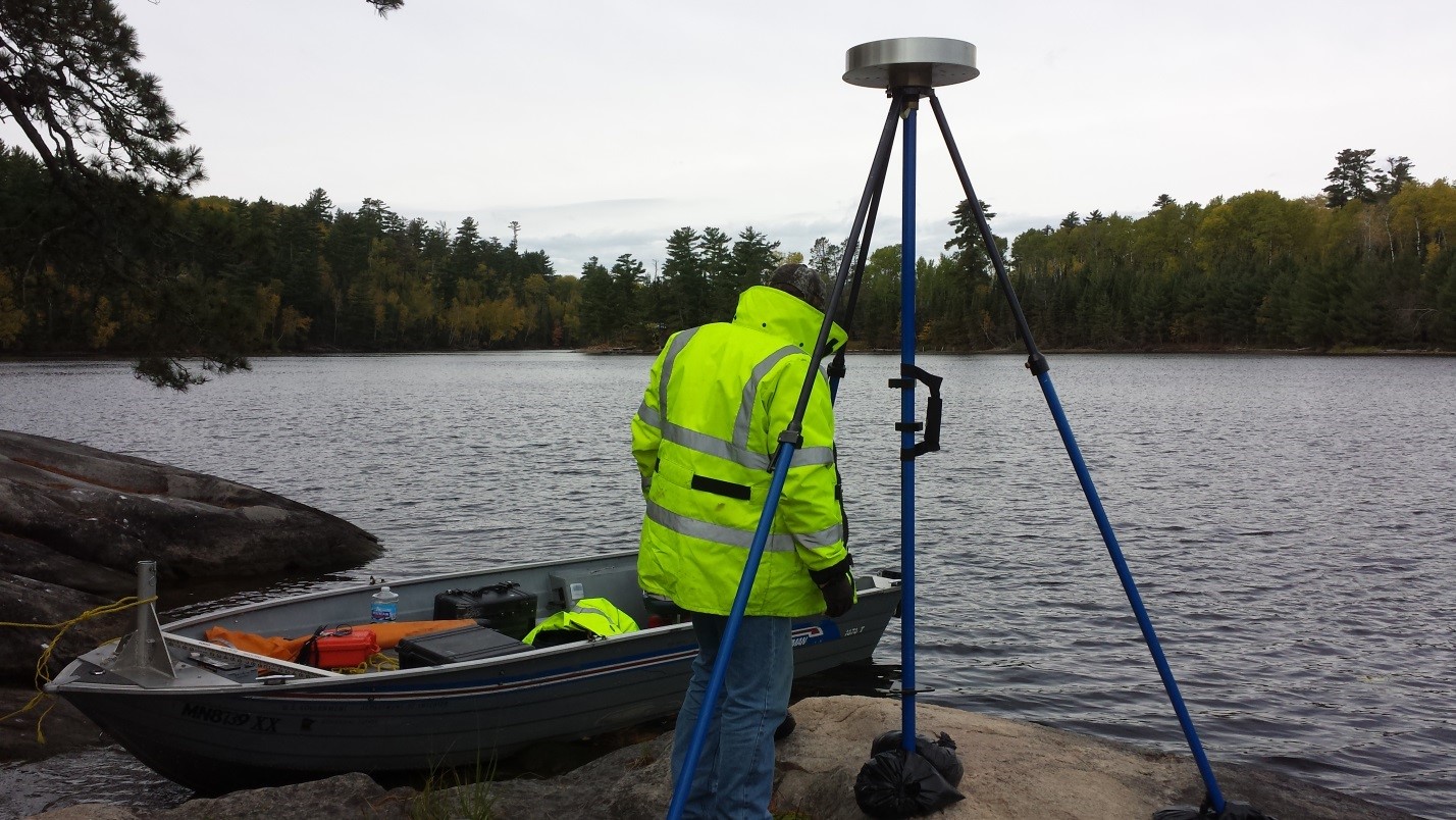 USGS Hydrologic Technician Justin Krahulik sets up surveying equipment off the lake shore. Credit:  U.S. Geological Survey