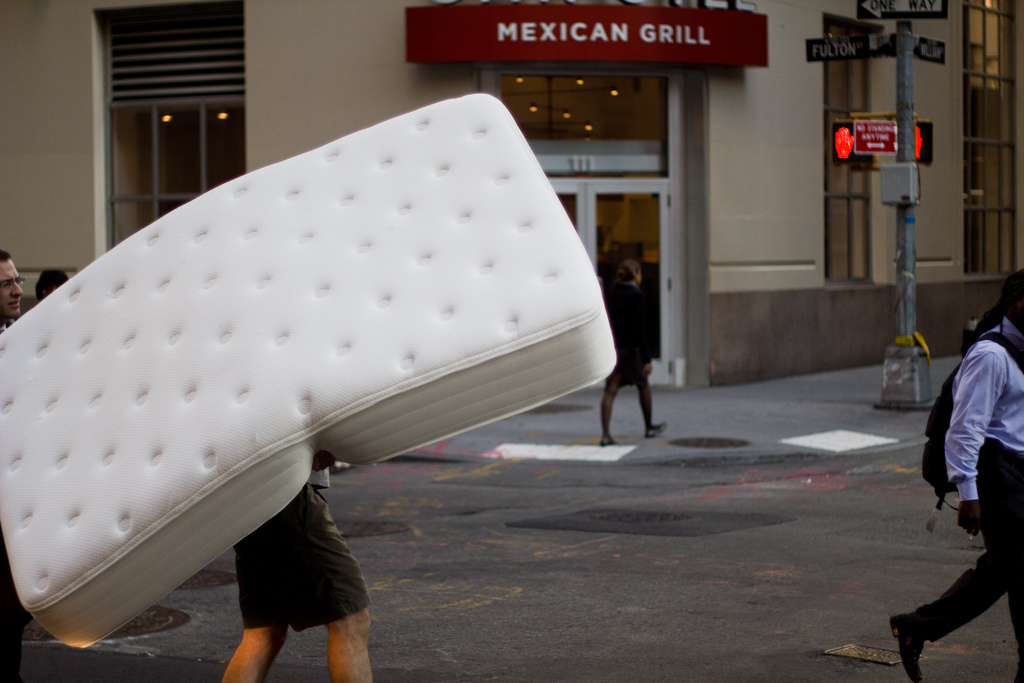 person carrying mattress