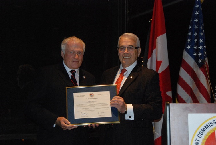 Commissioner Benoît Bouchard, right, thanks André Carpentier, left, for his service on the International St. Lawrence River Board of Control.